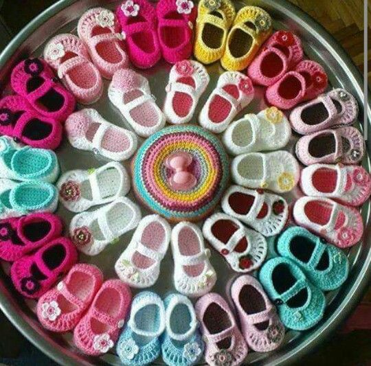 colorful knitted baby booties displayed in a circle