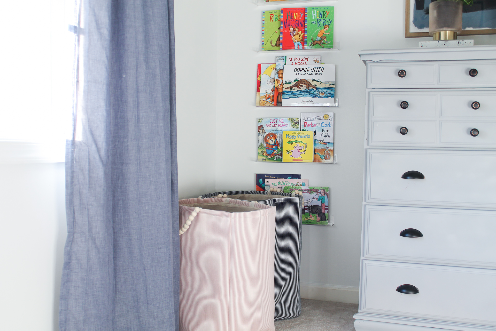 Pink and blue woven laundry baskets for kids toy storage.