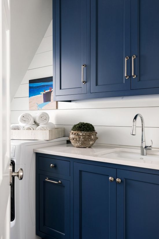 Sherwin Williams Blue Paint Color Naval cabinets in a laundry room paired with white shiplap for contrast.