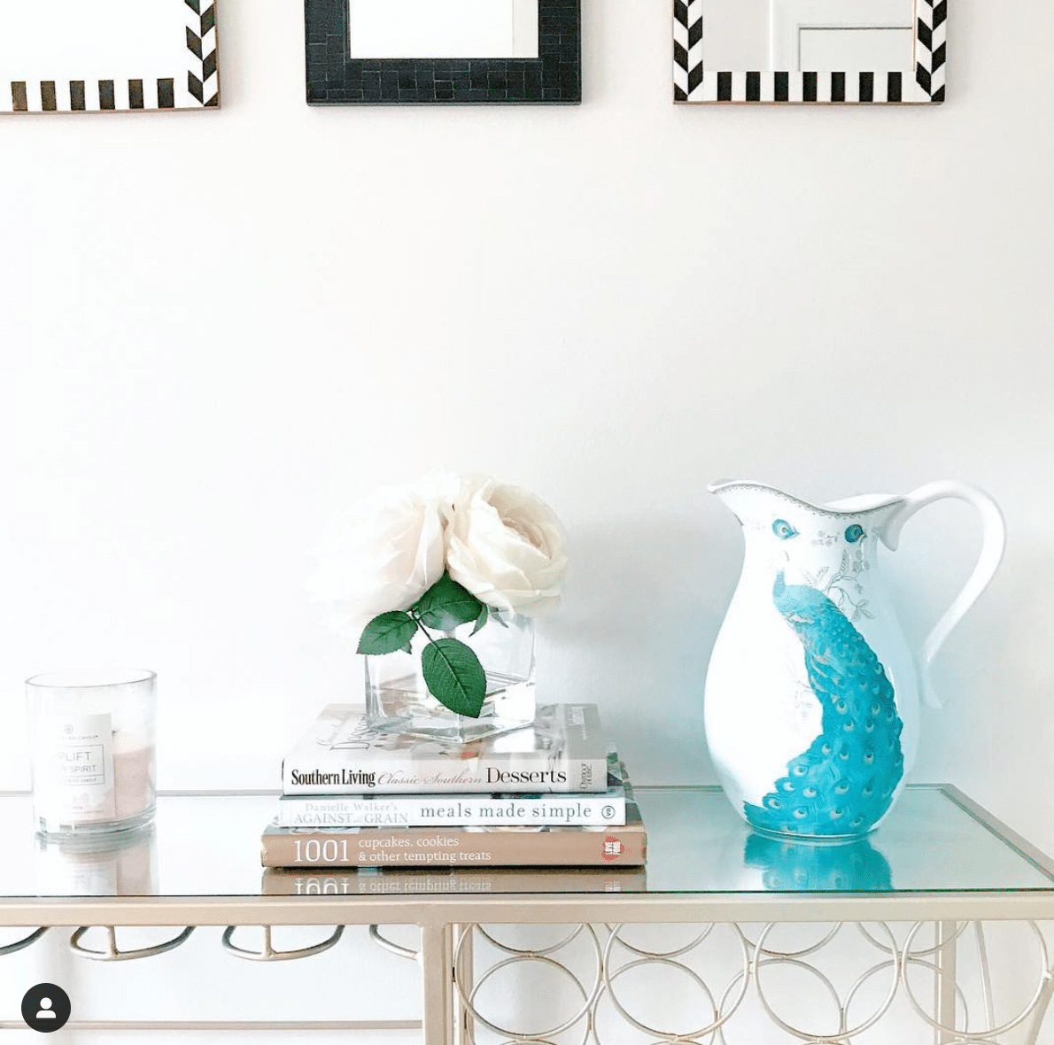 Hallway gold bar cart decorated with books and a vase.