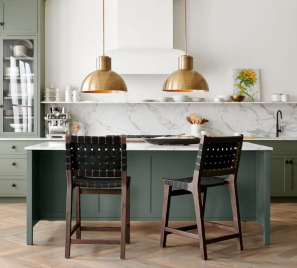 Green kitchen island with gold pendants