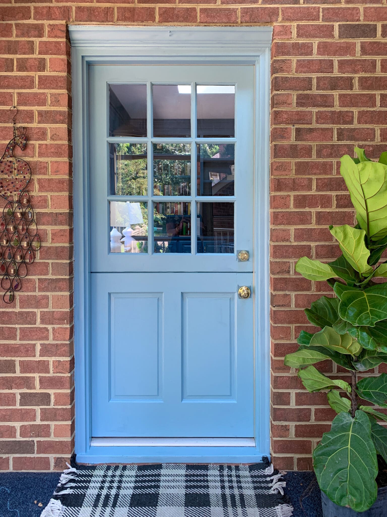 Our light blue Sherwin Williams Dutch Door open with the black dog peeking out.